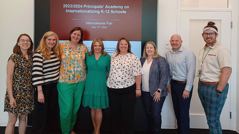 Group of teachers posing in front of sign